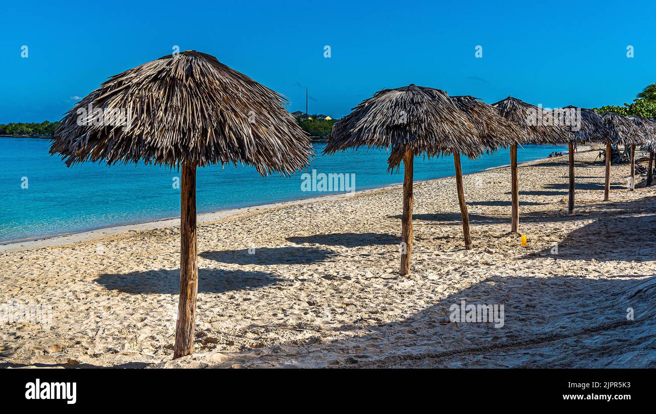 Holidays in one of the resorts near Holguin, Cuba, with a beautiful sandy beach surrounded by palm trees and warm ocean waves. Stock Photo