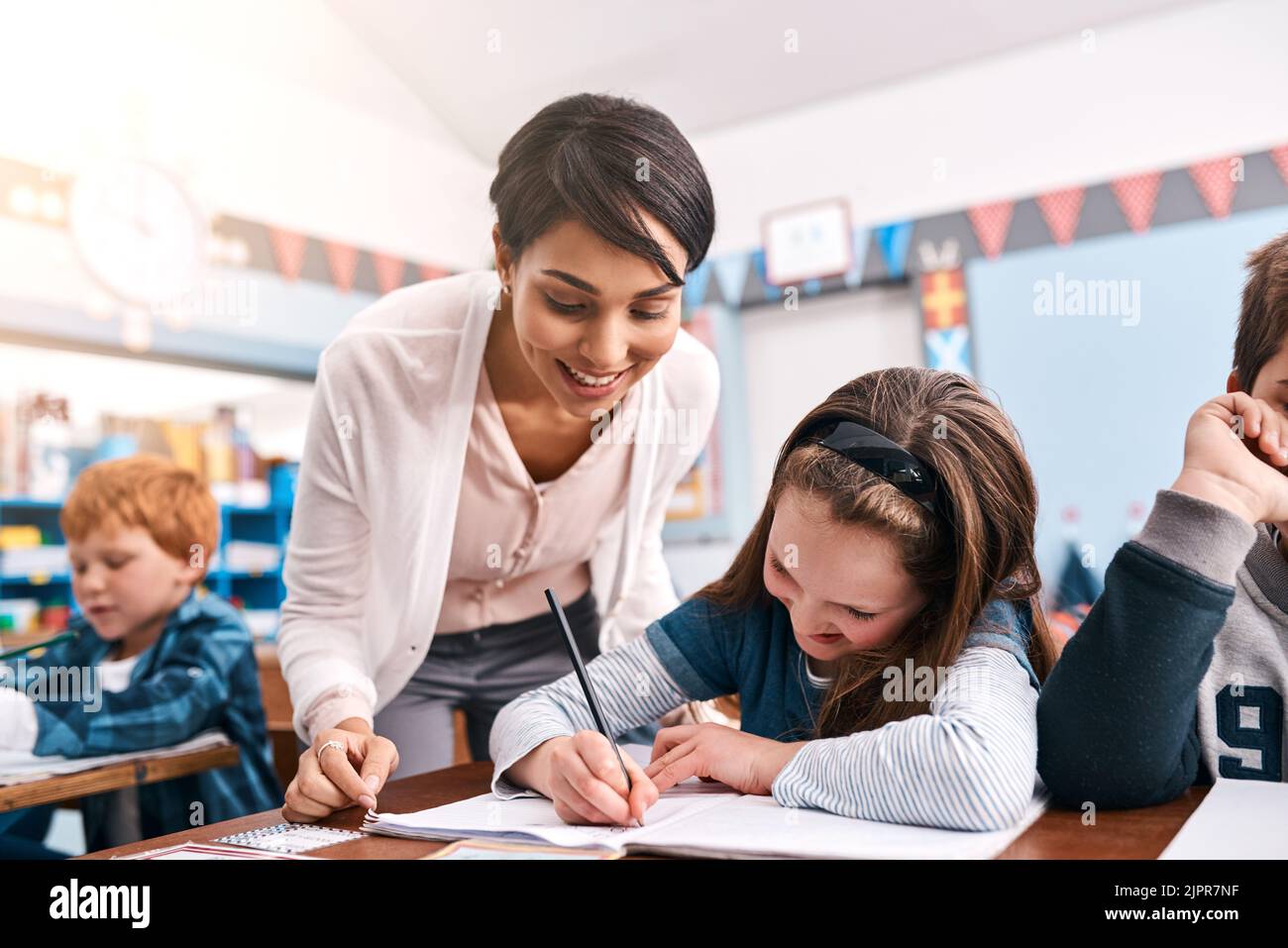 Keep trying. a cheerful young female teacher helping a student inside