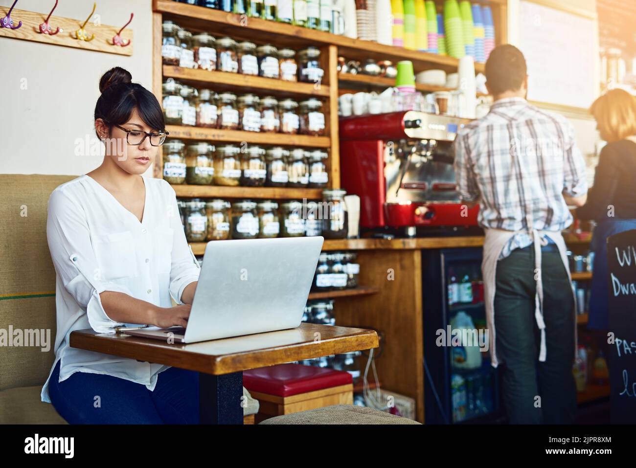 Coffee and connectivity is all I need. a beautiful young woman using a laptop in a cafe. Stock Photo