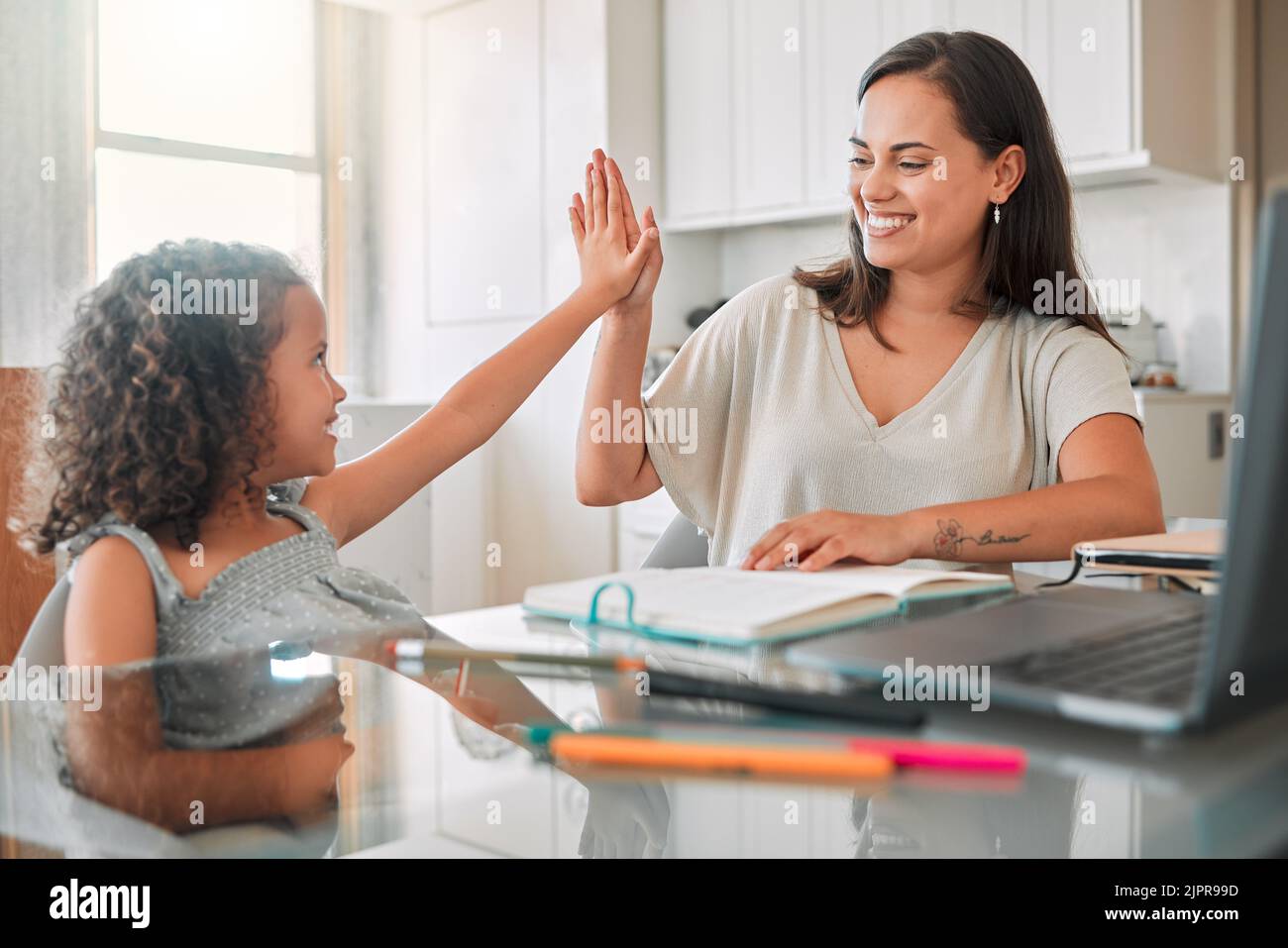 High five, homework and mom celebrating with preschool student for learning, goals and writing notes successfully. Teamwork, smile, and happy mom Stock Photo