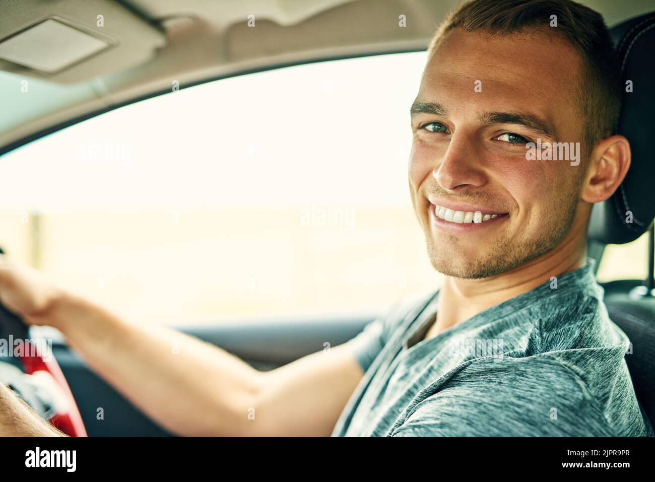 Weekends are when I take my wheels wherever I want. Portrait of a young man driving a car. Stock Photo