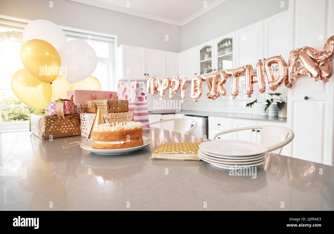 Birthday, kitchen and cake stand with balloons for house party. Happy event, gifts and baked sweet goods for guests to eat. Decorations, special Stock Photo