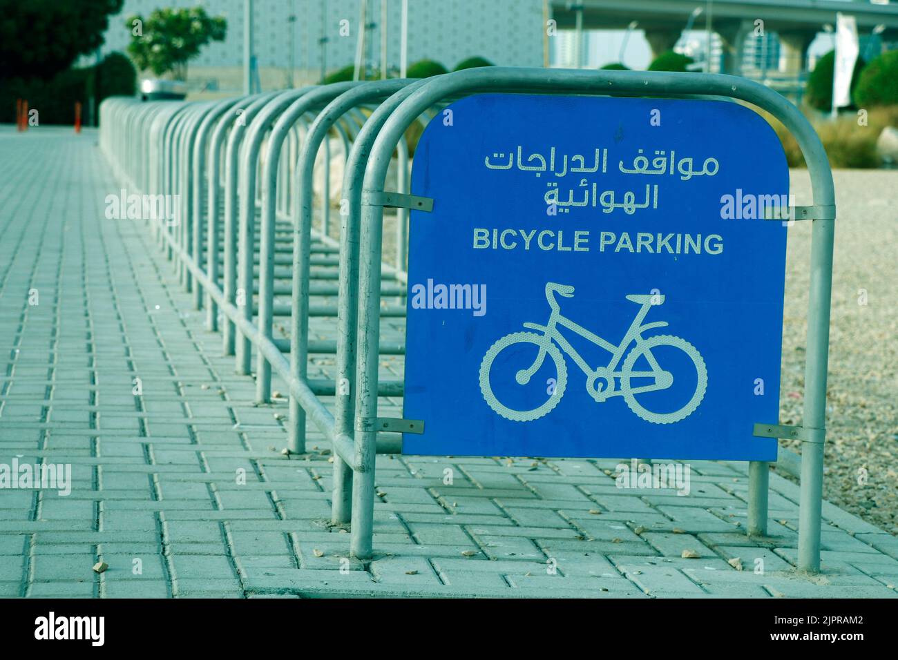 bicycle parking rack in street side with sign board in english and