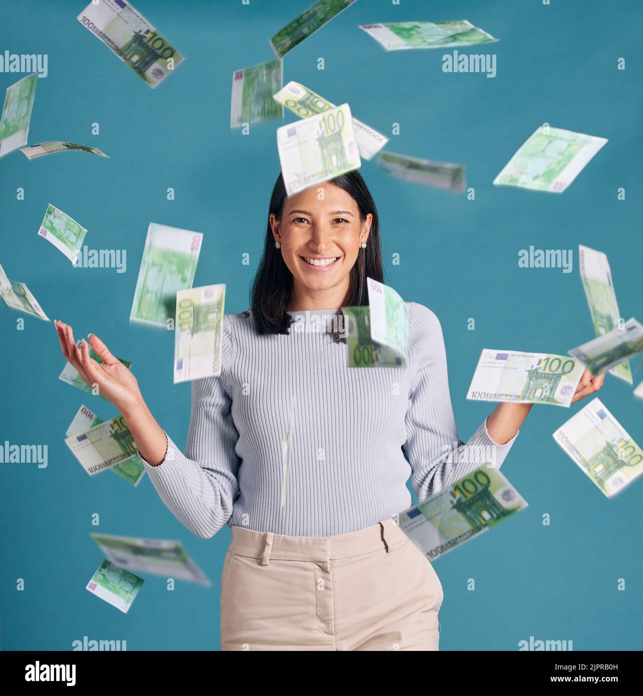 Wealthy, rich and money rain or falling from the sky for financial success and growth. Portrait of a successful, happy and excited female catching Stock Photo