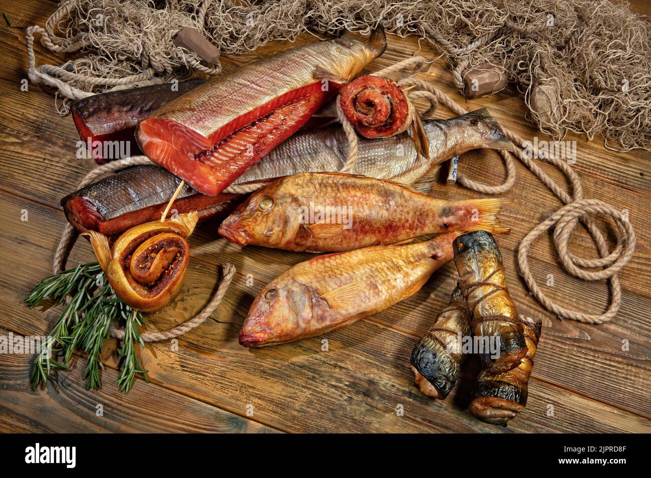 Different kinds of smoked fish and fushing net on a wooden desk