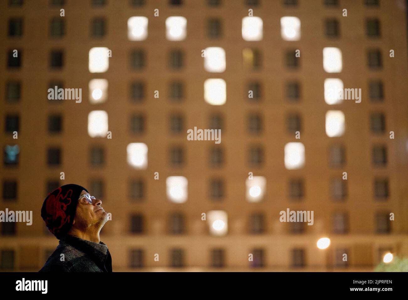 Gerard looks up to a hotel with a heart-shaped pattern of lights. Stock Photo