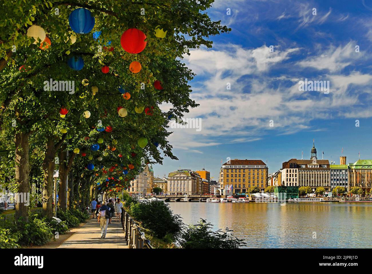 The trees on Ballindamm by the Inner Alster Lake are decorated with lanterns at Hamburg's summer gardens, Hamburg, Germany Stock Photo