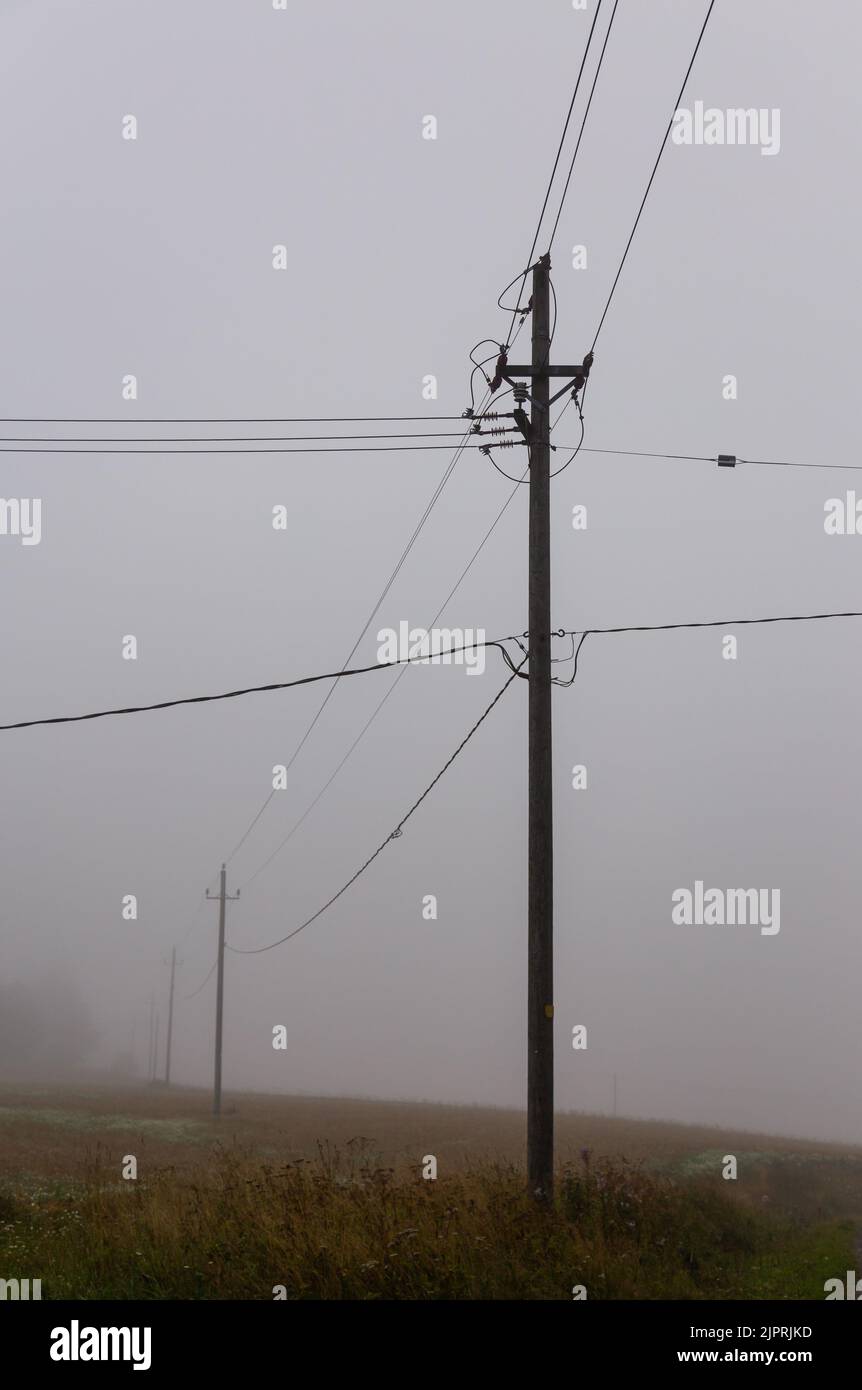 A foggy morning in the countryside in Finland, old electric and telephone wires running through the air. There is no people or built environment. Stock Photo