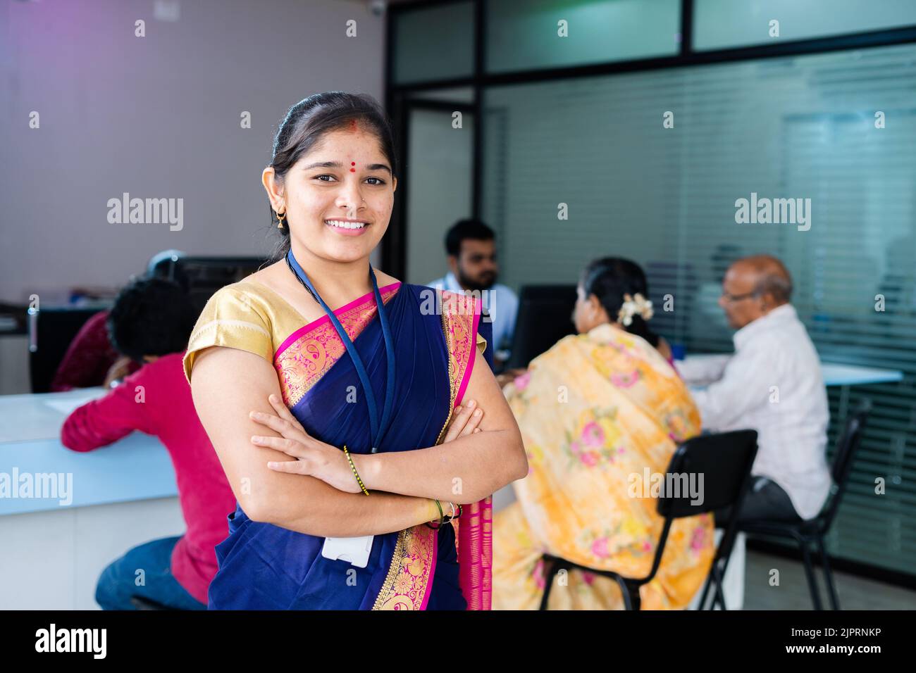 Happy confident bank employee standing with arms crossed by looking camera at office - concept of successful career, leadership and financial service Stock Photo