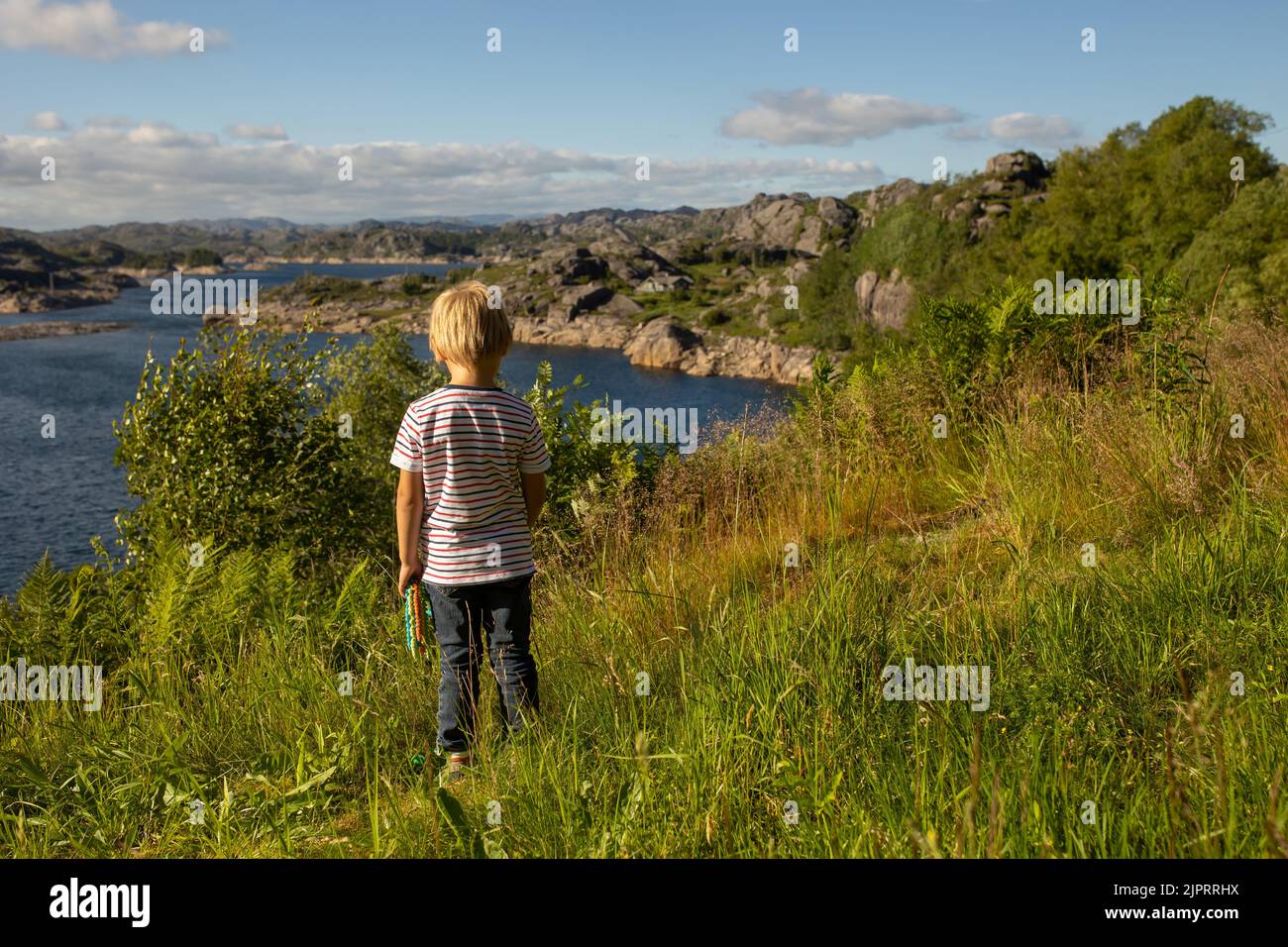 Happy people, enjoying amazing views in South Norway coastline, fjords, lakes, beautiful nature. Kids and adults traveling in Norway summertime Stock Photo