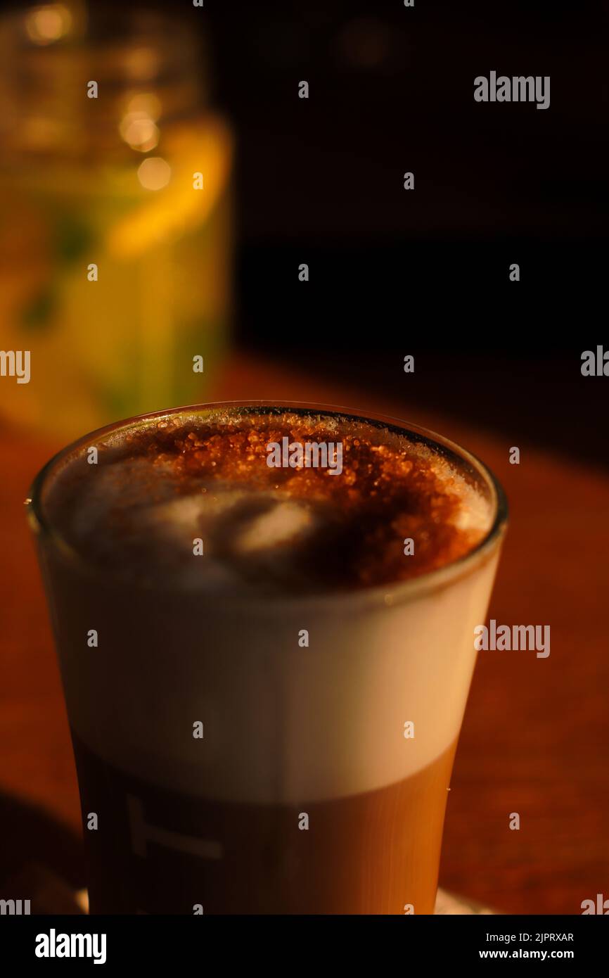 Coffee long cup glass, latte, milk and sugar, sunset light Stock Photo