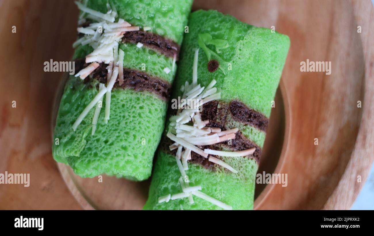 Pandanflavored green pancake rolls filled with pieces of coconut Stock