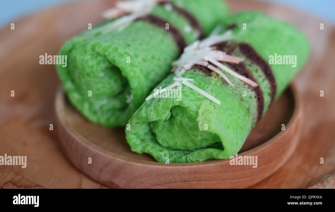 Pandanflavored green pancake rolls filled with pieces of coconut Stock