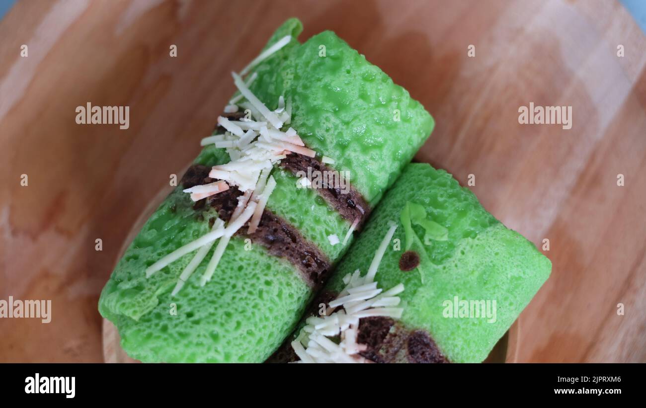 Pandanflavored green pancake rolls filled with pieces of coconut Stock