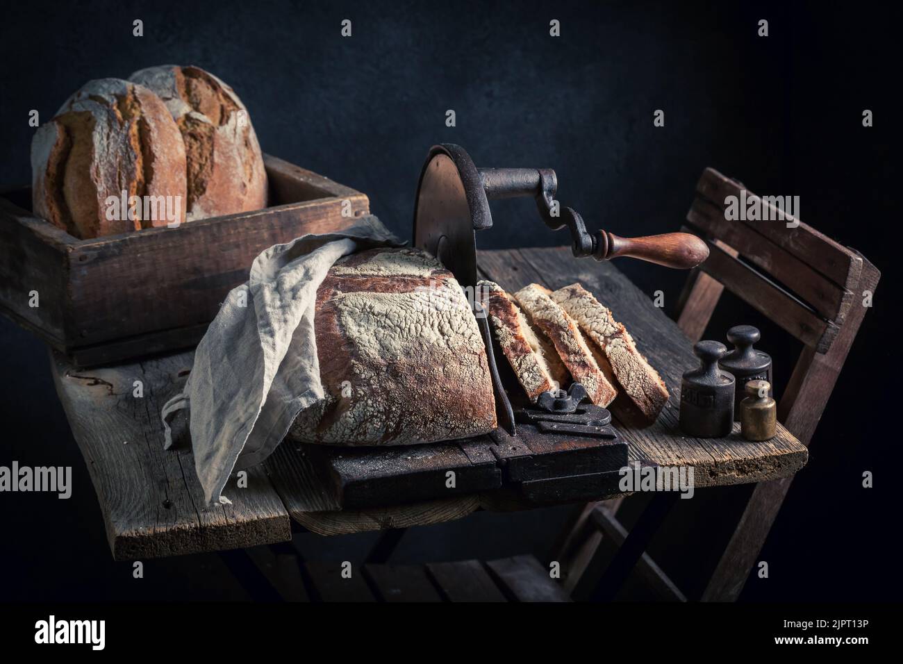 https://c8.alamy.com/comp/2JPT13P/homemade-and-rustic-loaf-of-bread-with-flour-and-crumbs-a-loaf-of-bread-on-a-crumb-slicer-2JPT13P.jpg