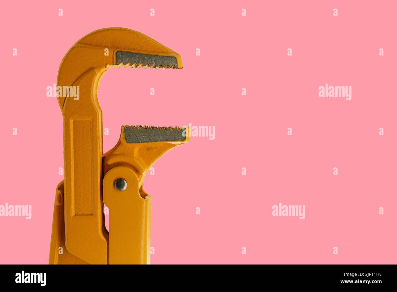 orange plumber wrench on a pink background. pipe wrench Stock Photo