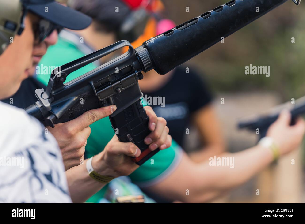 2022.08.07 Modlin, Poland - Group of people training how to operate guns. Firearm training at firing range. Safety gear. Close-up of submachine gun. Outdoor horizontal shot . High quality photo Stock Photo