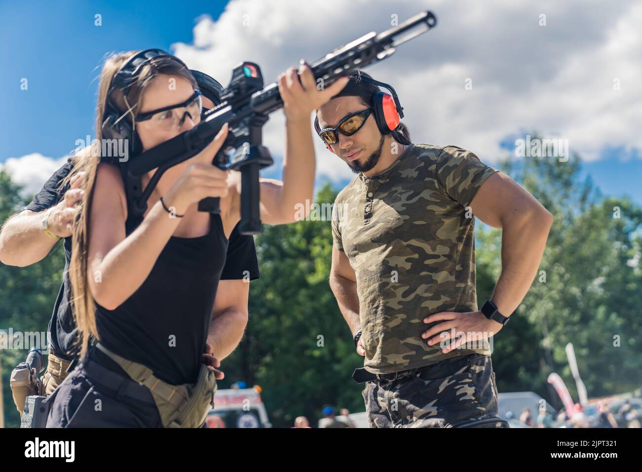 Man and woman wearing safety headphones and goggles practicing using