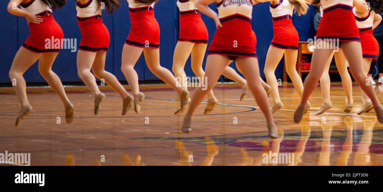 High school kickline team dancing at half time of a basketball game