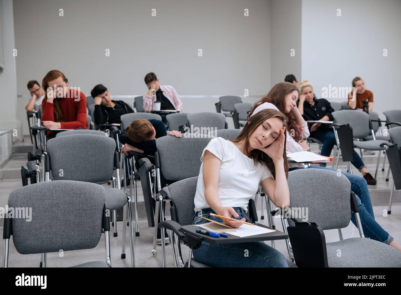 A break between classes in high school. Students rest and sleep in the classroom because of the large number of lessons and overwork. Stock Photo