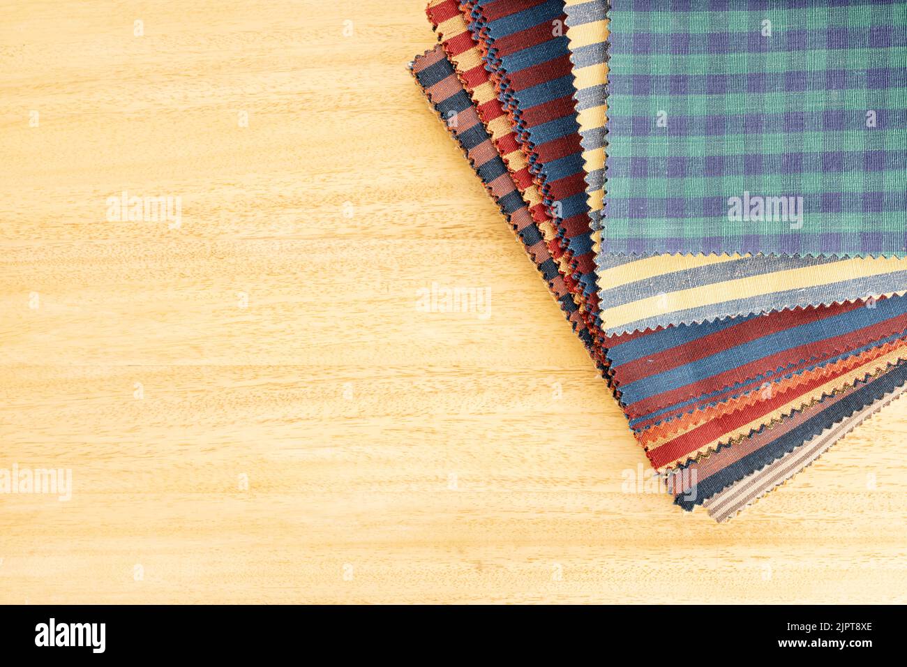Fabric textile catalog on wooden table. Fabric samples upholstery and decoration. Copy space Stock Photo