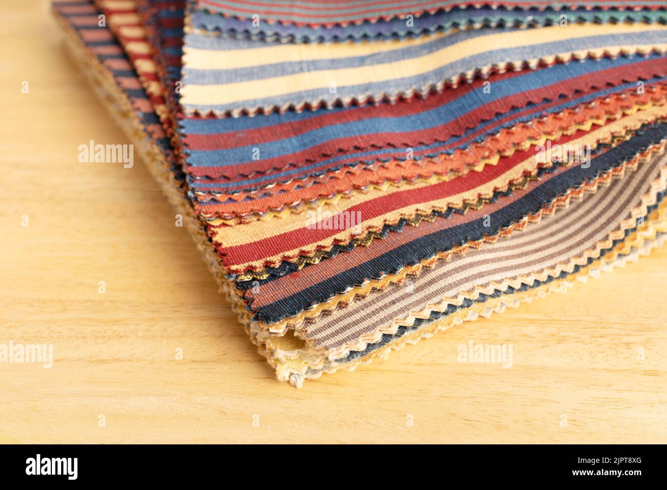 Fabric textile catalog on wooden table. Fabric samples upholstery and decoration. Stock Photo