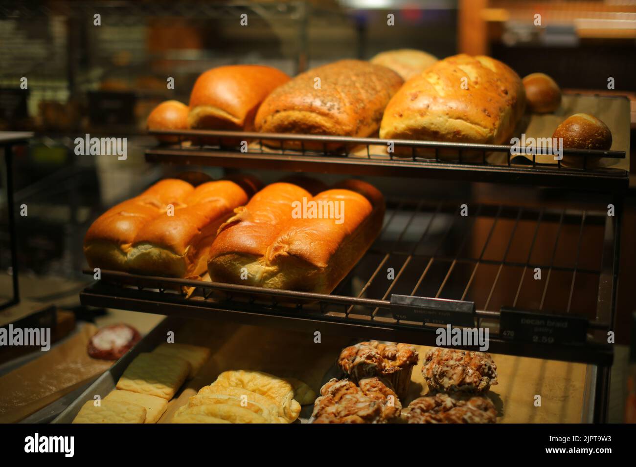 A closeup of fresh baked hot bread on the counters at the bakery shop Stock Photo