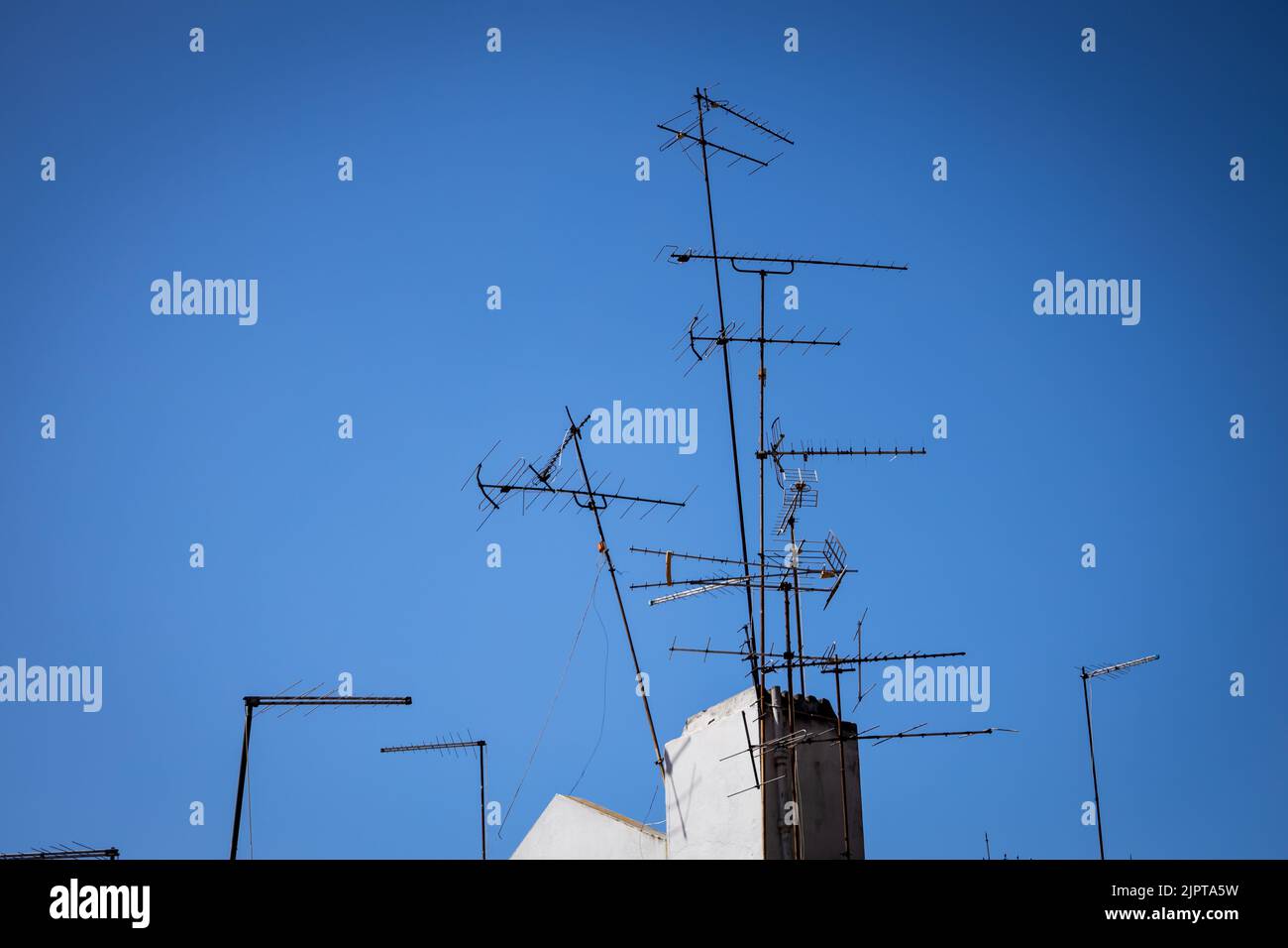several old television antennas on a roof. old tv signal reception system. free space to write. Stock Photo