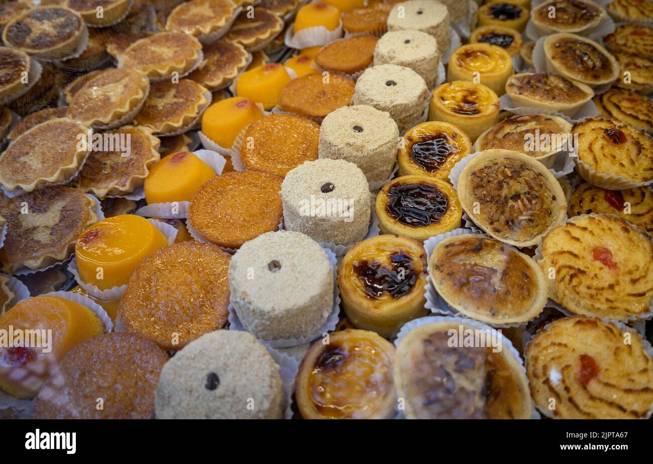 Delicious little cakes in a glass window. Artisan pastry. foods rich in refined sugar. Stock Photo