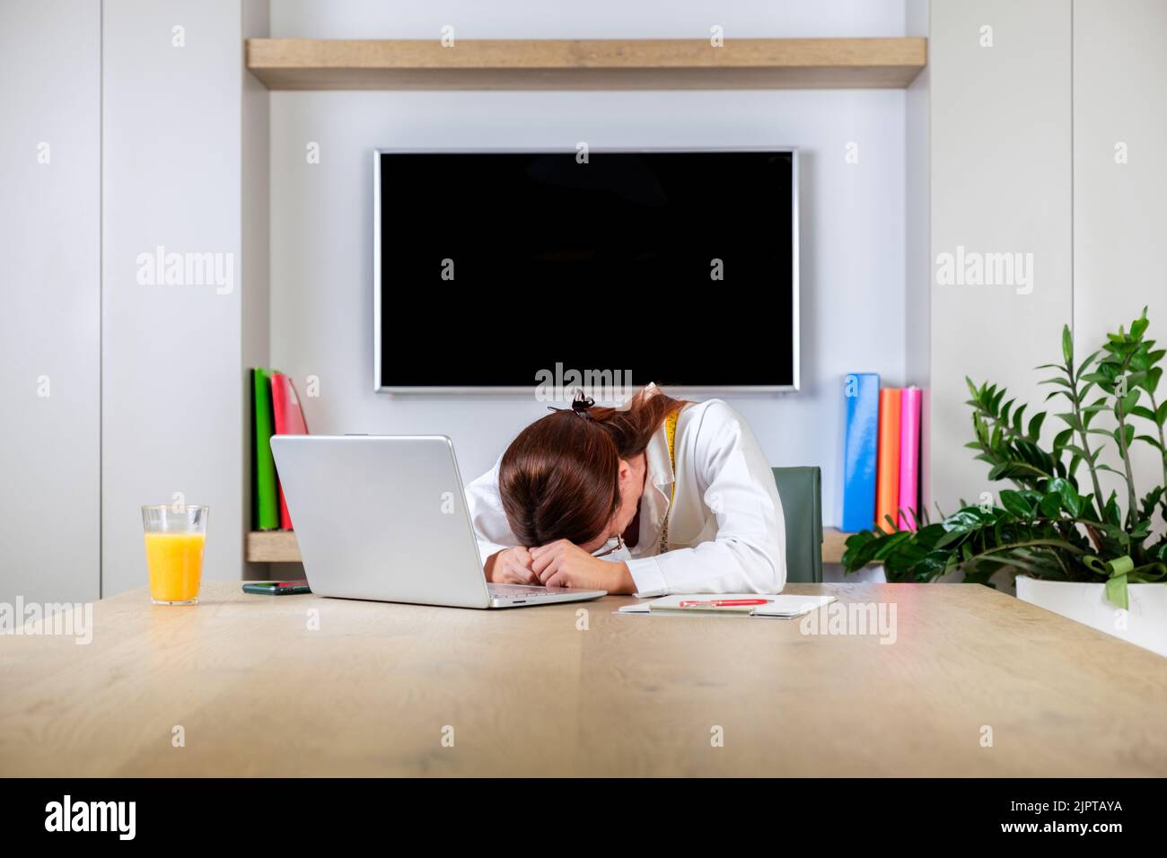 Young nutritionist woman working looking sideways with doubtful and skeptical expression. Dietologist doctor tressed and frustrated Stock Photo