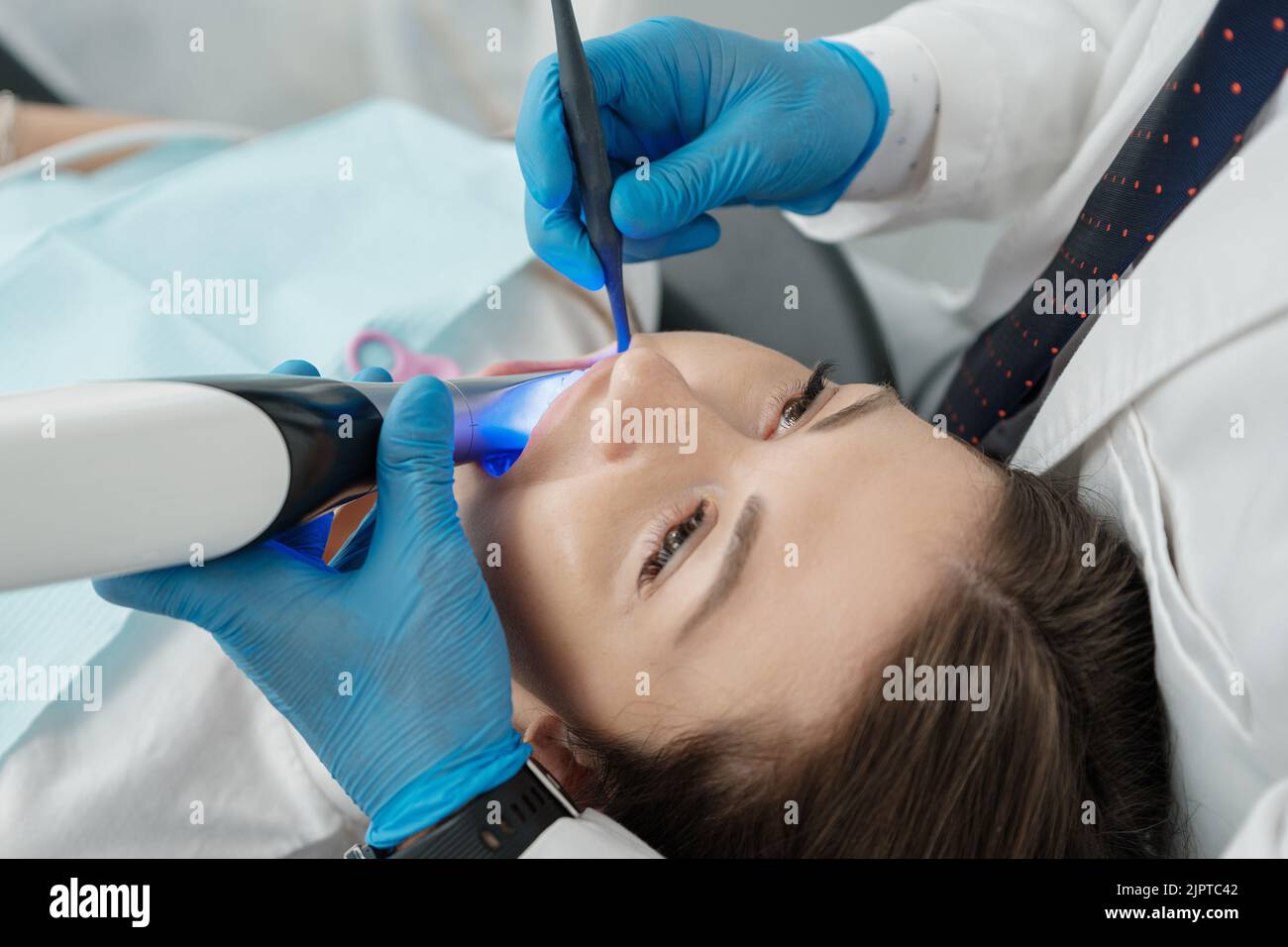 Closeup of female patient in dental chair on a procedure of intraoral