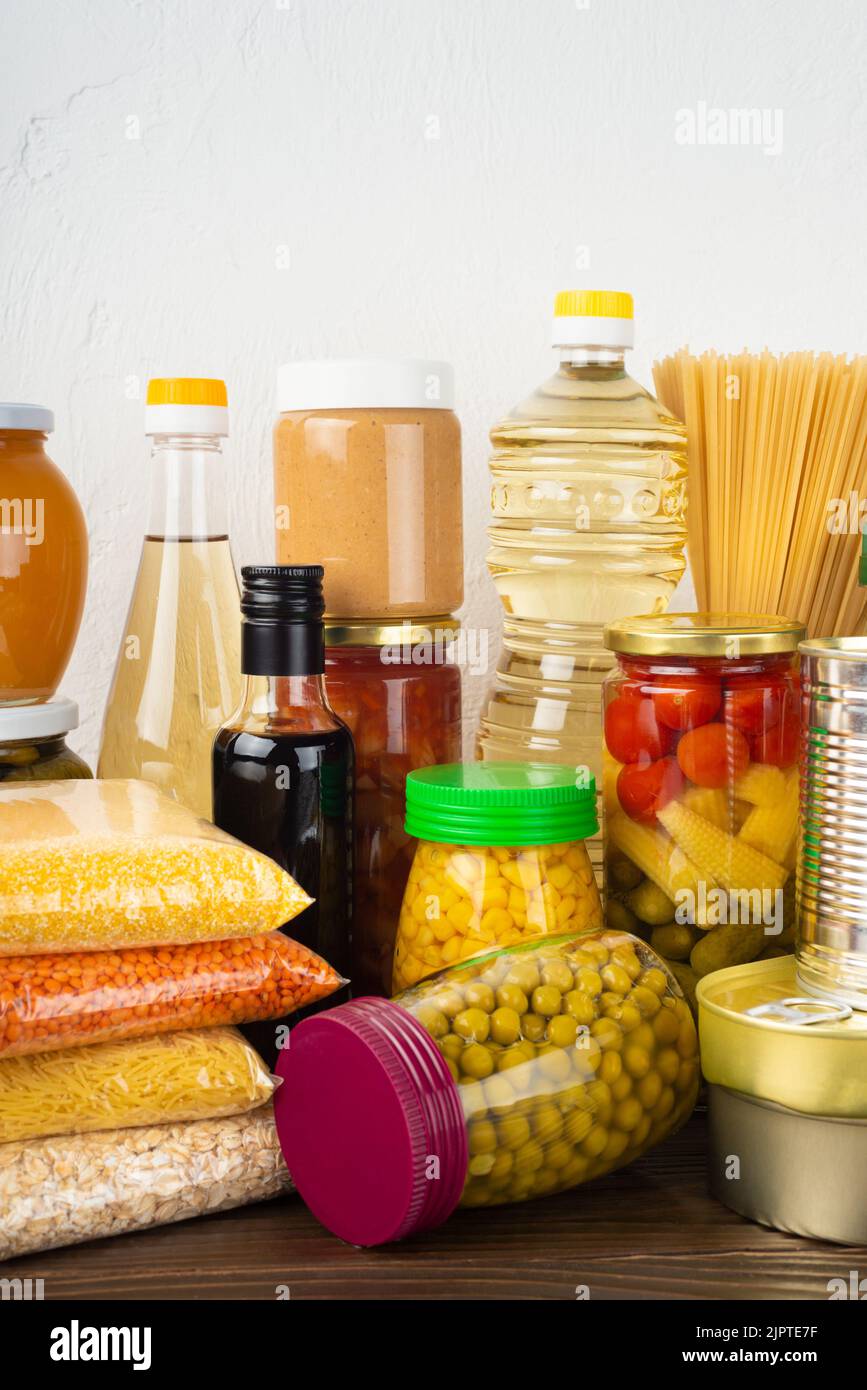 Emergency survival food set on dark wooden kitchen table Stock Photo