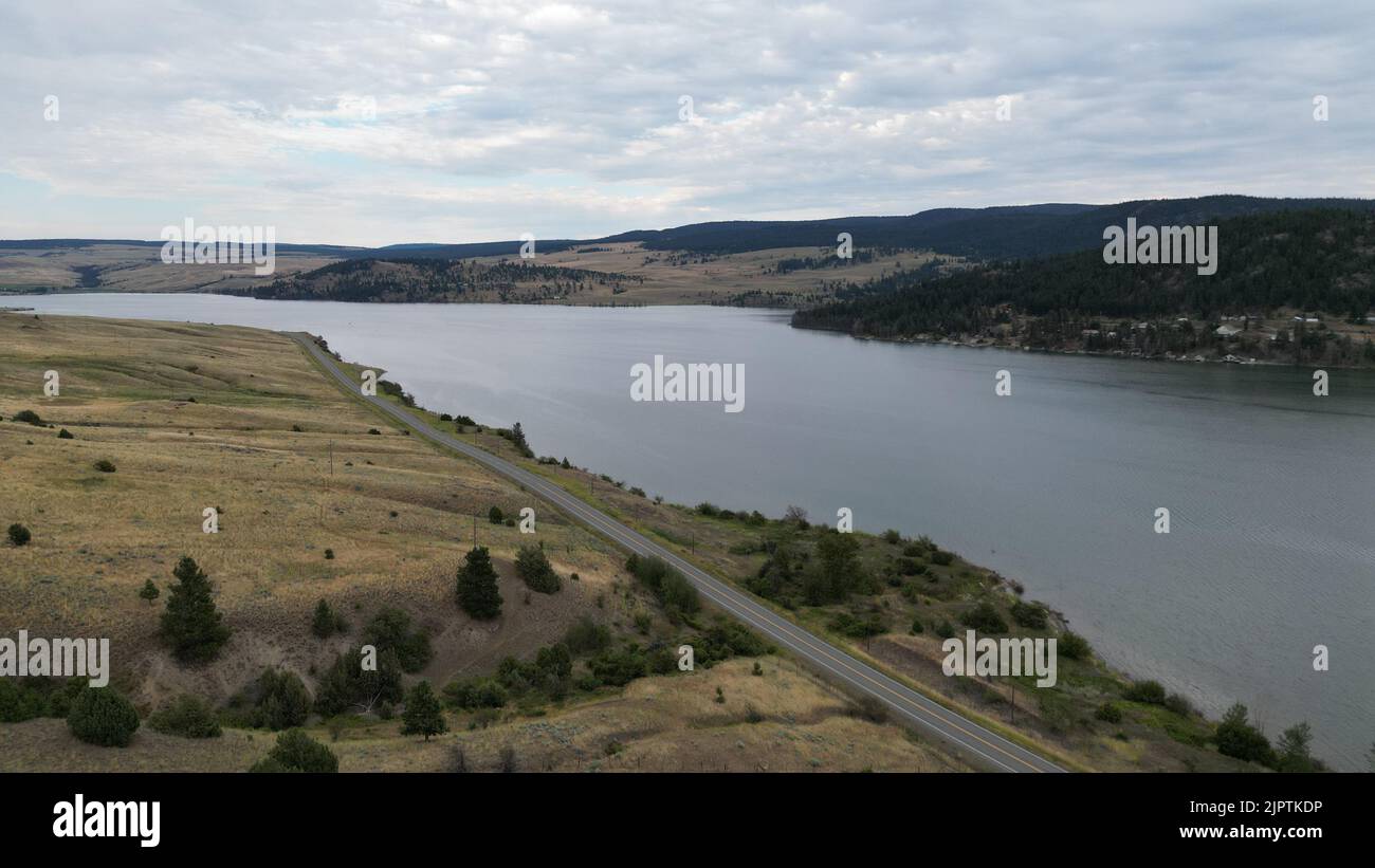 A scenic view of river and trees on a mountain under blue sky ...