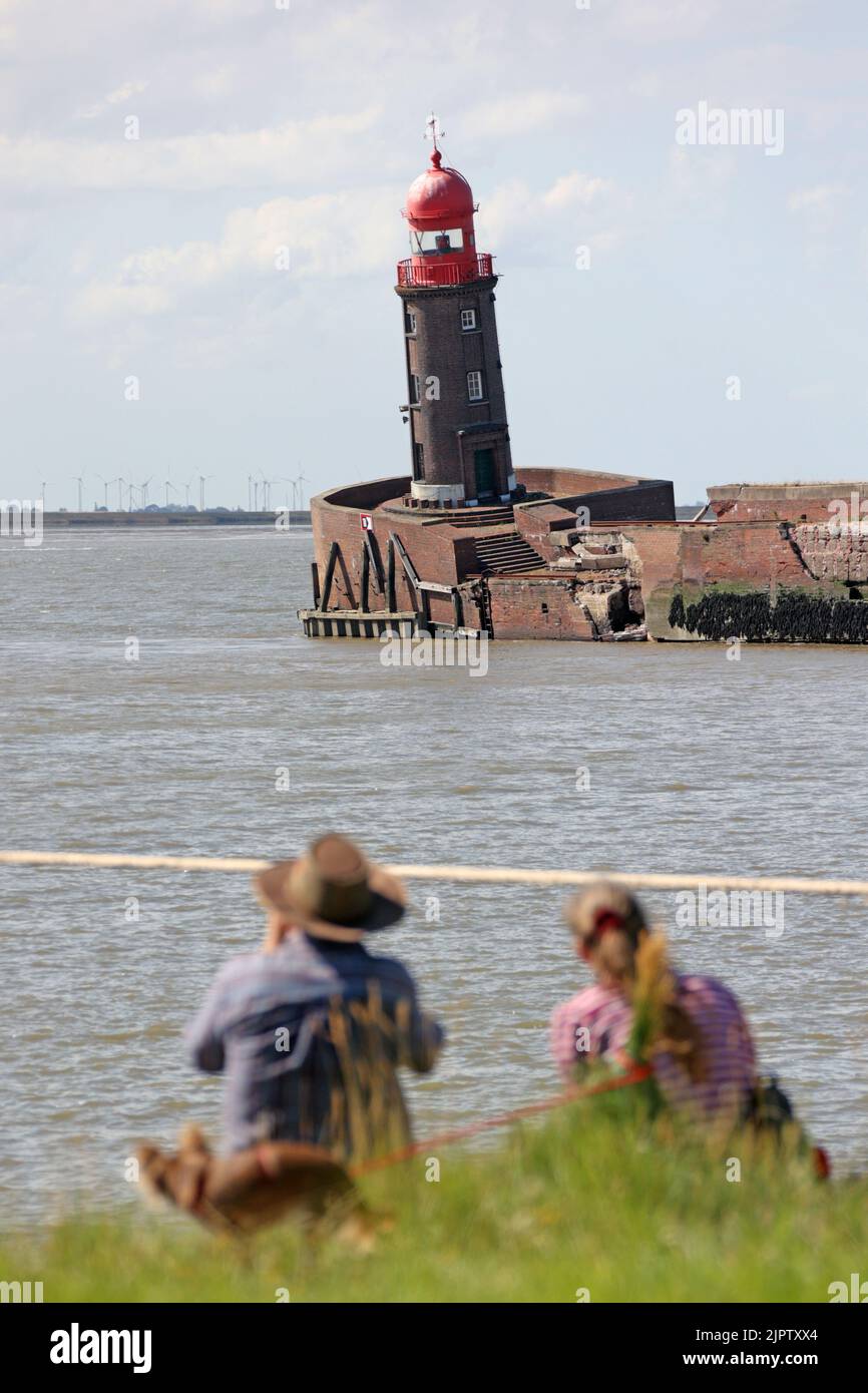 20 August 2022, Bremen, Bremerhaven: Onlookers watch the lowered Mole tower in Bremerhaven. In the night to Thursday, the north pier, at the top of which stands the beacon with the red head, had sunk, whereby the tower, which is about 20 meters high, got into a threatening inclination. Photo: Markus Hibbeler/dpa Stock Photo