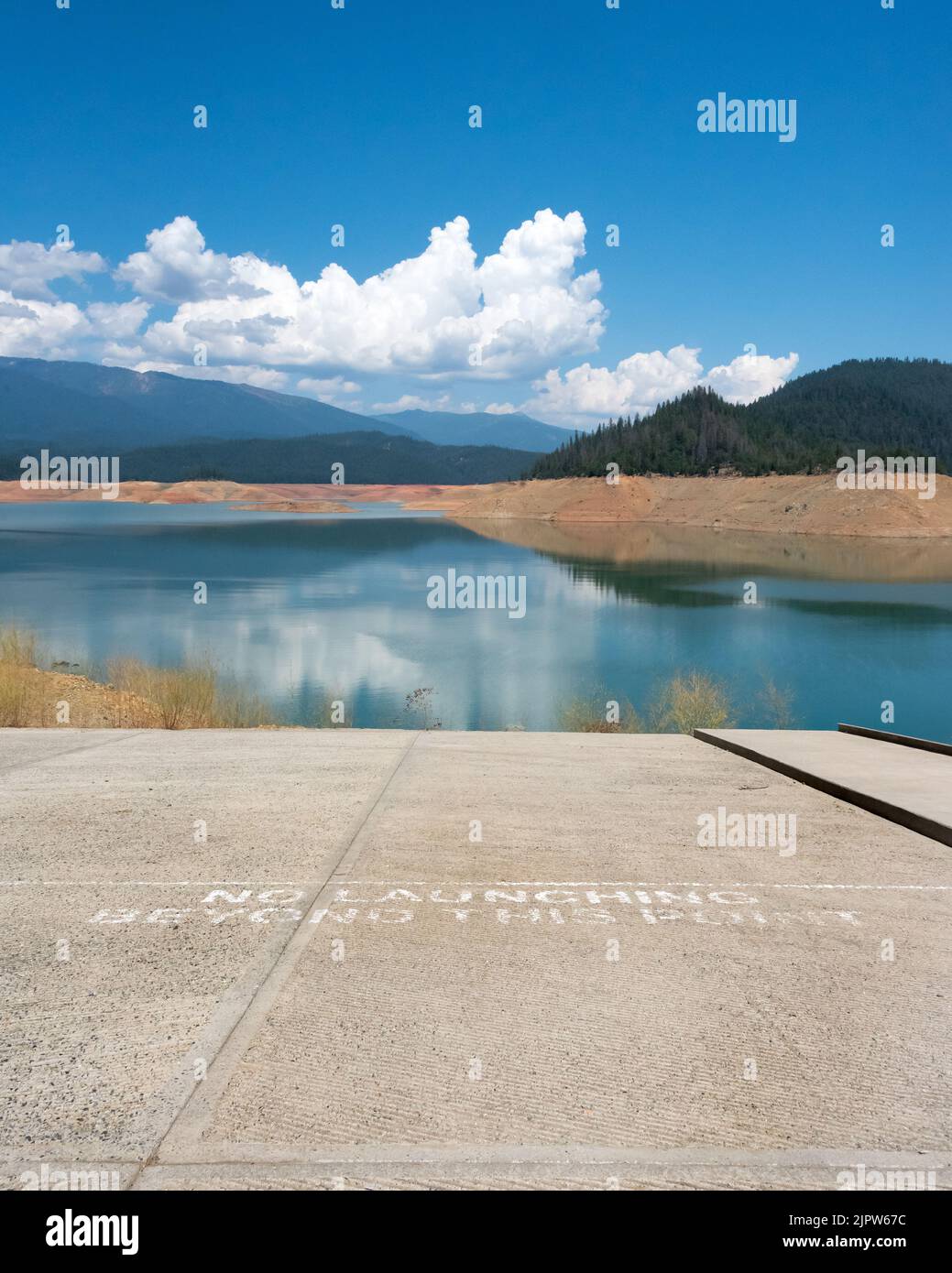 View from end of boat launch ramp, dropping off several stories above Trinity Lake reservoir at 25% capacity during severe drought in California. Stock Photo