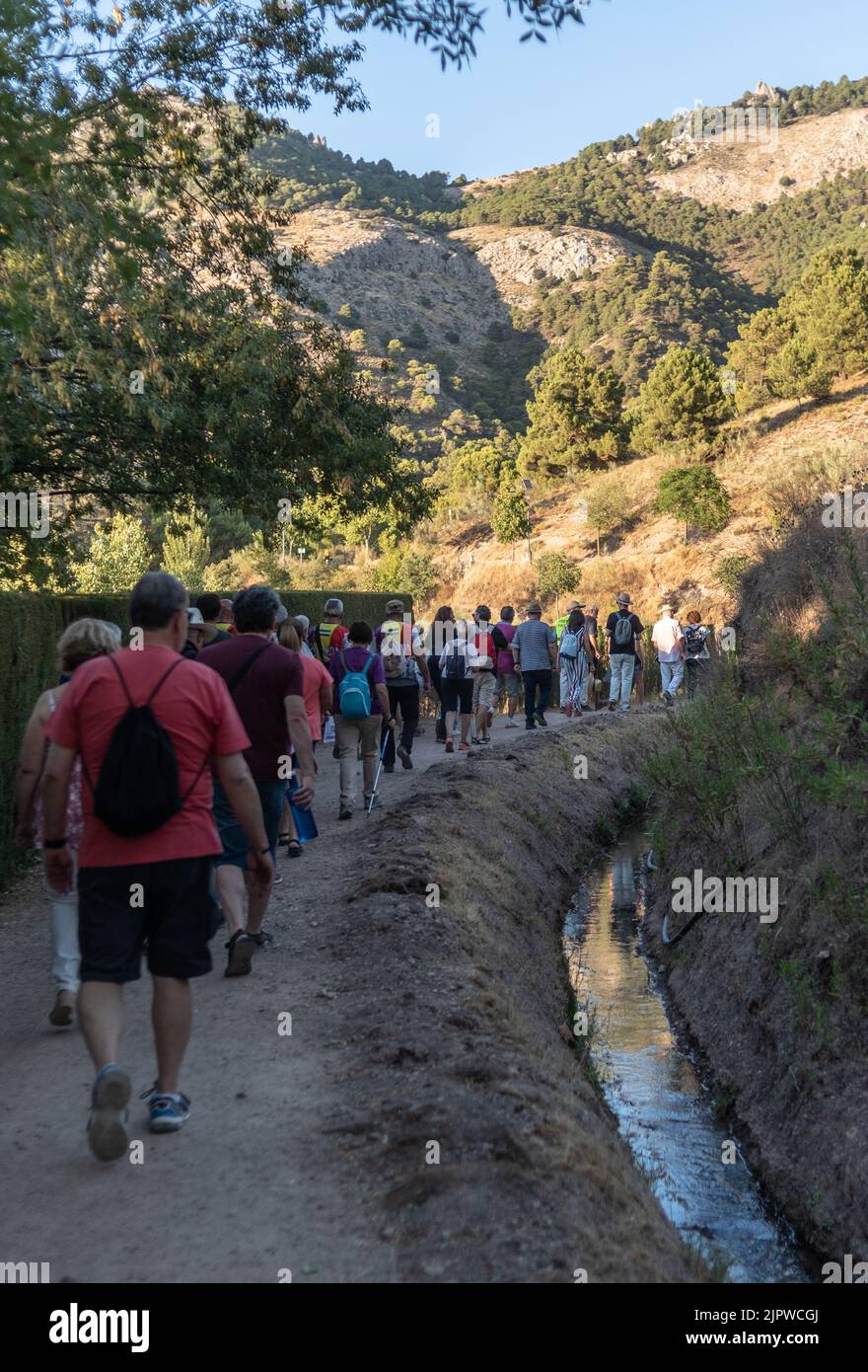 Viznar, Granada, Spain, August 18, 2022: Group of people walking next to the acequia aynadamar on the occasion of the popular march in tribute to Fede Stock Photo