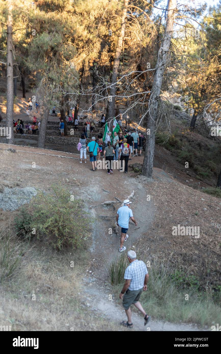 Viznar, Granada, Spain, August 18, 2022: Group of people walking along a path in the Viznar ravine on the occasion of the popular march in tribute to Stock Photo
