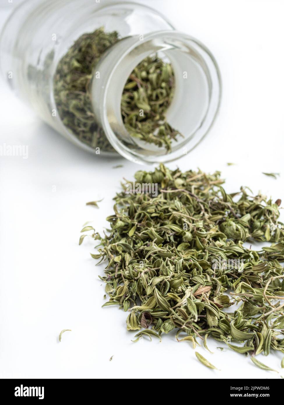 Dried thyme leaves in jar on white background. Herbs for health. Copy
