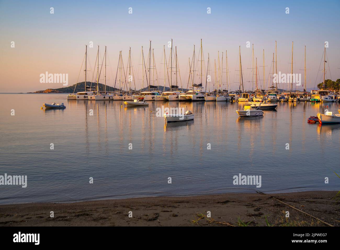 View of boats overlooking Skiathos Town at sunrise, Skiathos Island, Sporades Islands, Greek Islands, Greece, Europe Stock Photo
