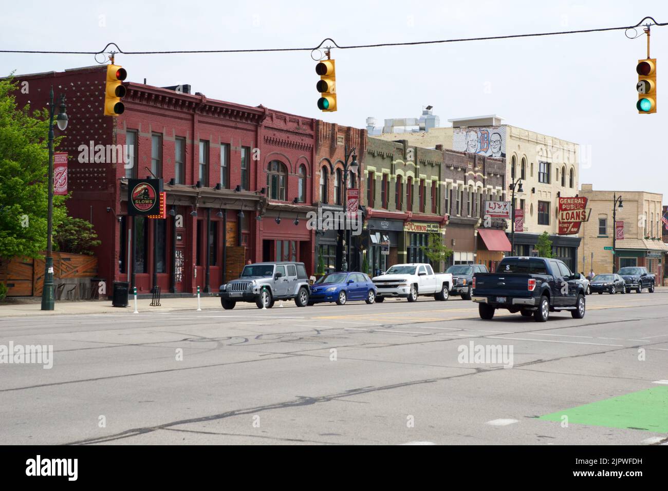 DETROIT, MICHIGAN, UNITED STATES - MAY 22, 2018: street with traffic lights, cars and low houses with stores in a suburb of Detroit Stock Photo
