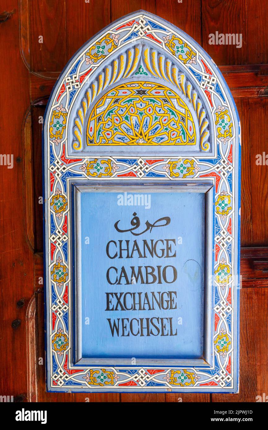 Chefchaouen, Morocco.  Sign on money exchange shop in five languages: Arabic, French, Spanish, English and German.  Arabic art motifs. Stock Photo