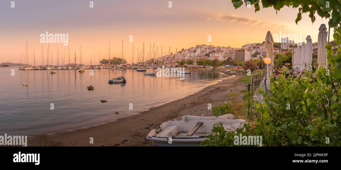 View of boats and restaurants in Skiathos Town at sunset, Skiathos Island, Sporades Islands, Greek Islands, Greece, Europe Stock Photo