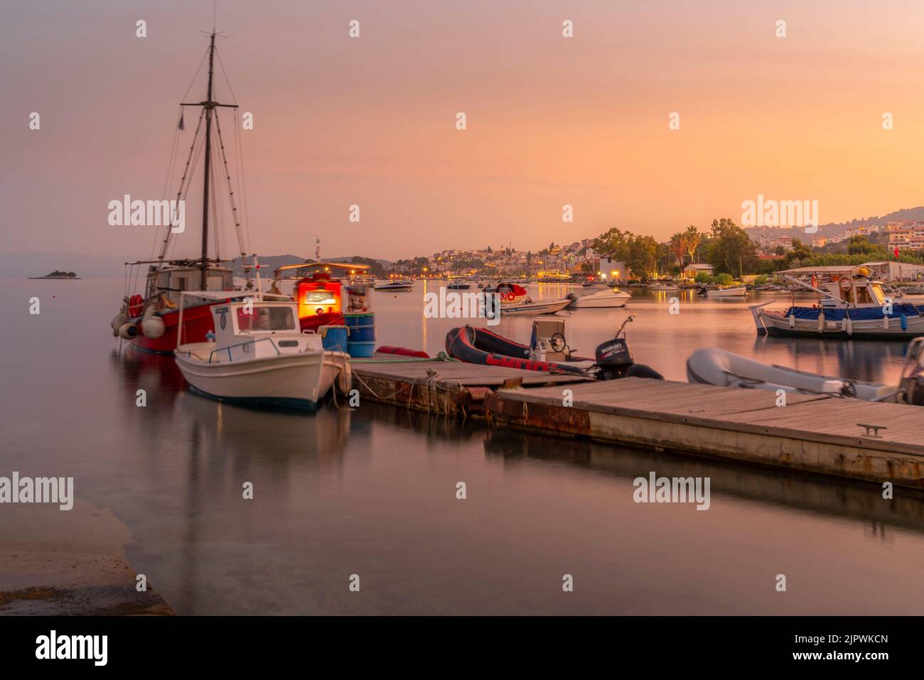 View of boats and Skiathos Town at sunset, Skiathos Island, Sporades Islands, Greek Islands, Greece, Europe Stock Photo