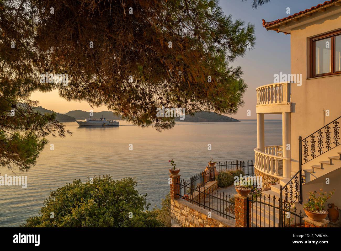 View of ferry arriving in the old town at sunrise, Skiathos Town, Skiathos Island, Sporades Islands, Greek Islands, Greece, Europe Stock Photo