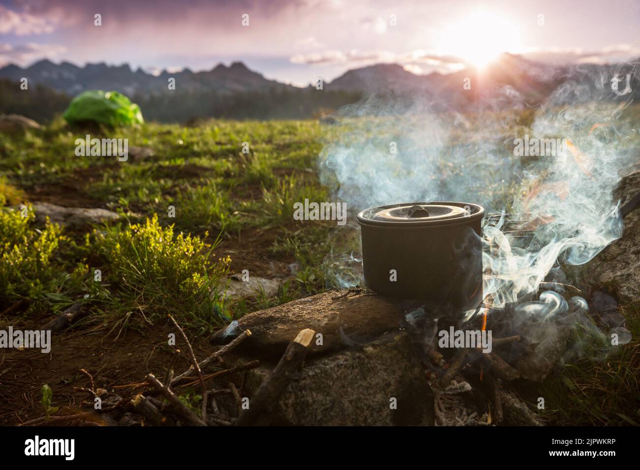 Touristic kettle on fire of burning campfire in camping in the hike