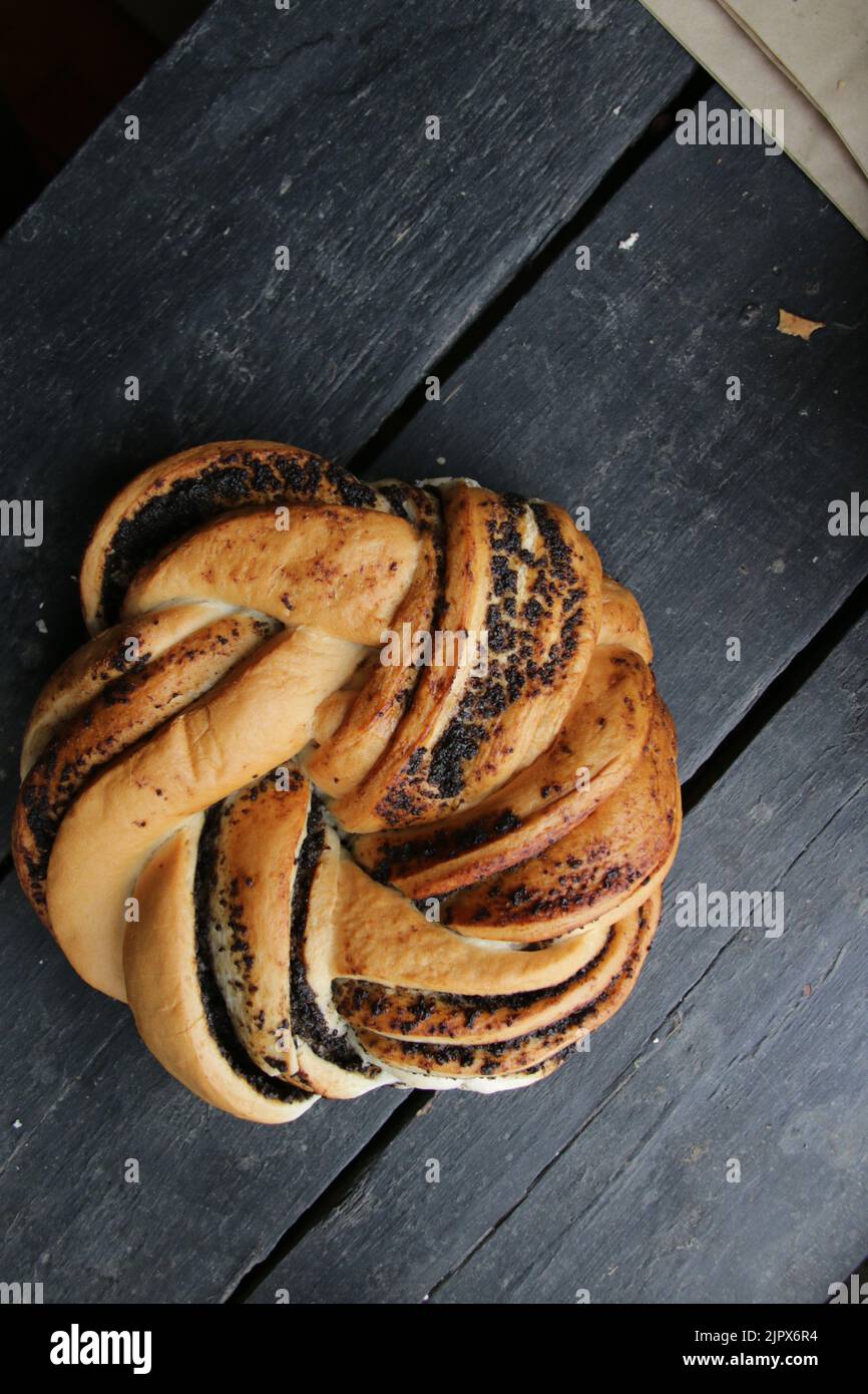 Sweet roll with poppy seeds On a beautiful wooden background Stock Photo