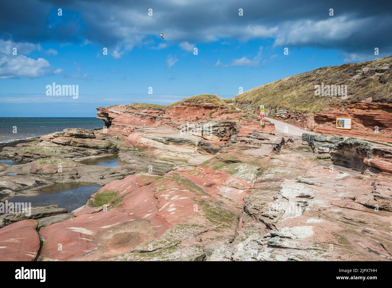 The red sandstone cliffs on Hilbre Island seen in the Dee Estuary in August 2022. Stock Photo