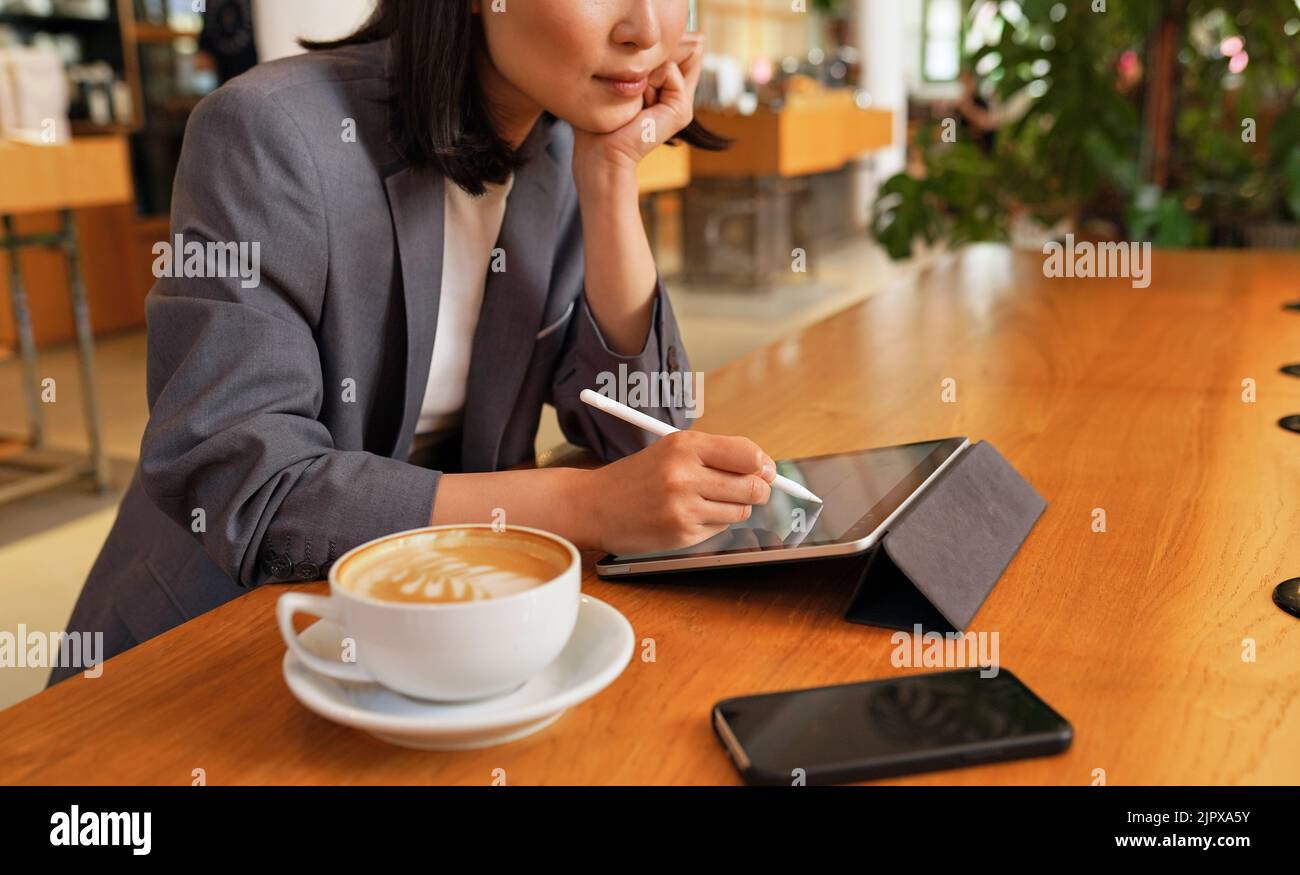 Young business woman using digital tablet working sitting in cafe. Stock Photo