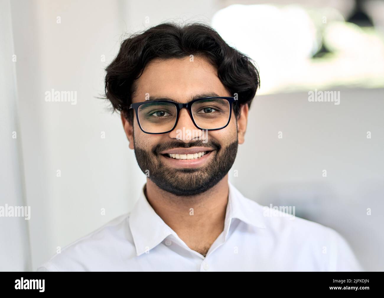 Smiling young indian business man wearing eyeglasses, headshot portrait. Stock Photo