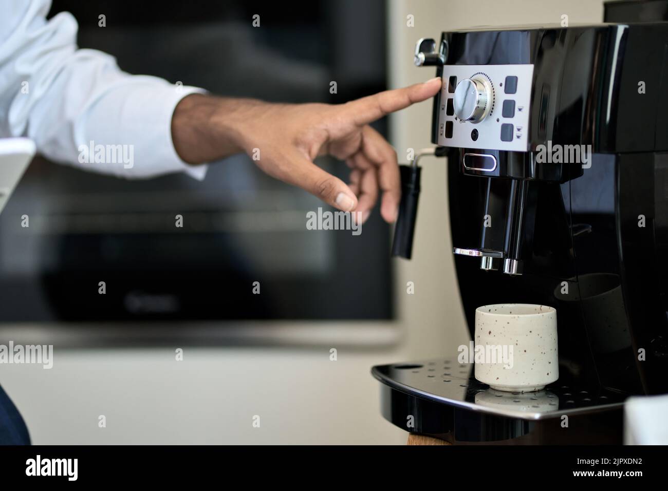 Male hand making coffee in machine in cafe or office. Close up Stock Photo